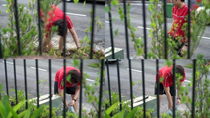 勤劳的亚洲华人成年男性正在清理杂草丛生的花园
