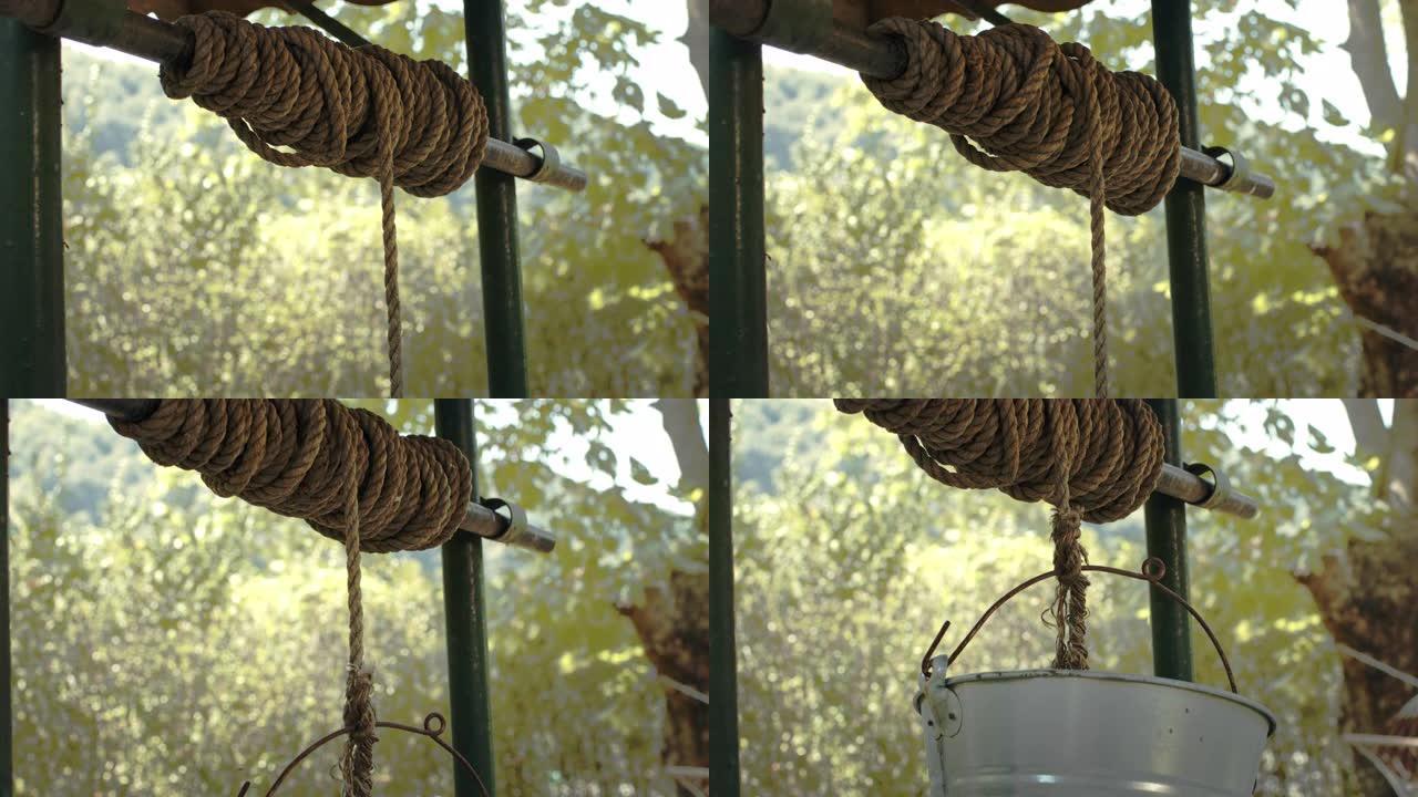 老式绳子的特写镜头，用慢速的铁桶从老井取水