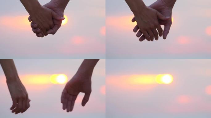 背景中与阳光分离的手的特写镜头。两个恋人之间美丽的浪漫时刻以分手告终。成熟的关系。关系心理学。一对夫