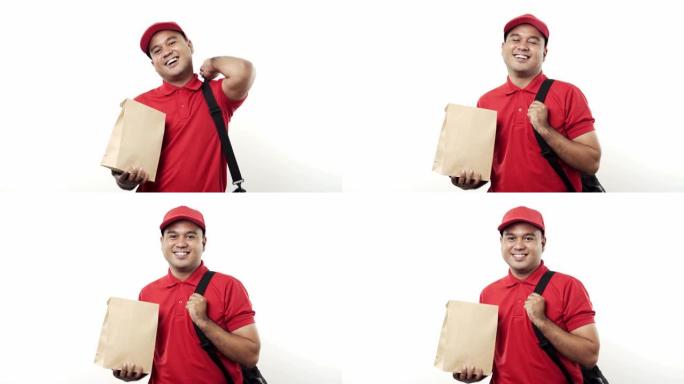 微笑的年轻亚洲送货员穿着红色制服，拿着包裹纸袋站在孤立的白色背景上。4k分辨率。