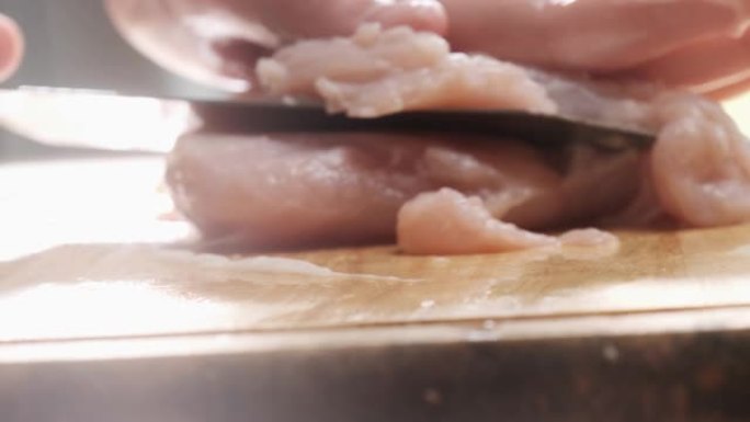 轻盈慢动作在砧板上切鸡肉。