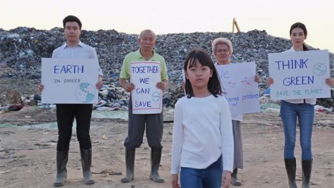 亚洲人群举着竞选标志作为志愿者或抗议。女孩用她的手对着镜头。抗议者、活动家、志愿服务、污染和有毒废物