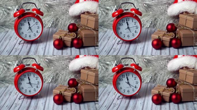 红色复古闹钟和木桌上的三个礼品盒，上面装饰着花环和红色圣诞球，适合新年或圣诞节。复制空间