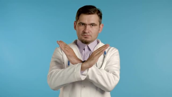 专业医疗白大褂的严肃医生肖像显示不，停止交叉手势，否定，停顿手势。否认，不同意。男人医生孤立在蓝色背