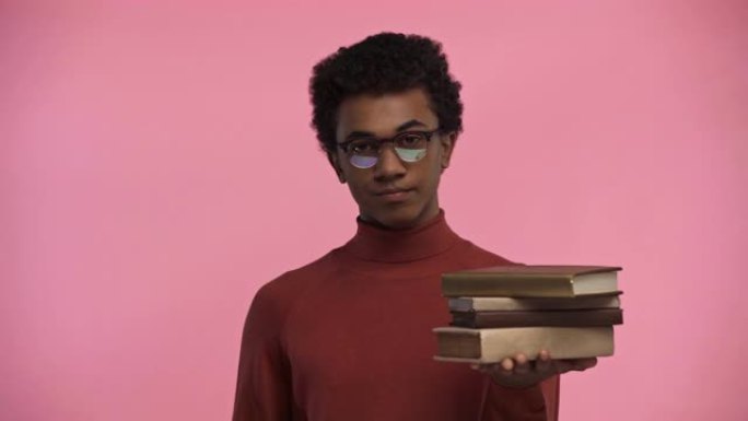 非裔美国少年拿着粉红色孤立的书