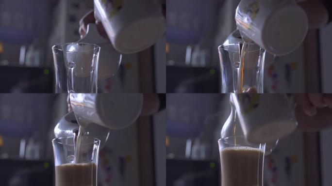 将咖啡和牛奶倒入咖啡杯的特写镜头。厨房里的热早饮。家庭食物和饮料。咖啡杯热饮料。茶壶里的早餐茶。一天