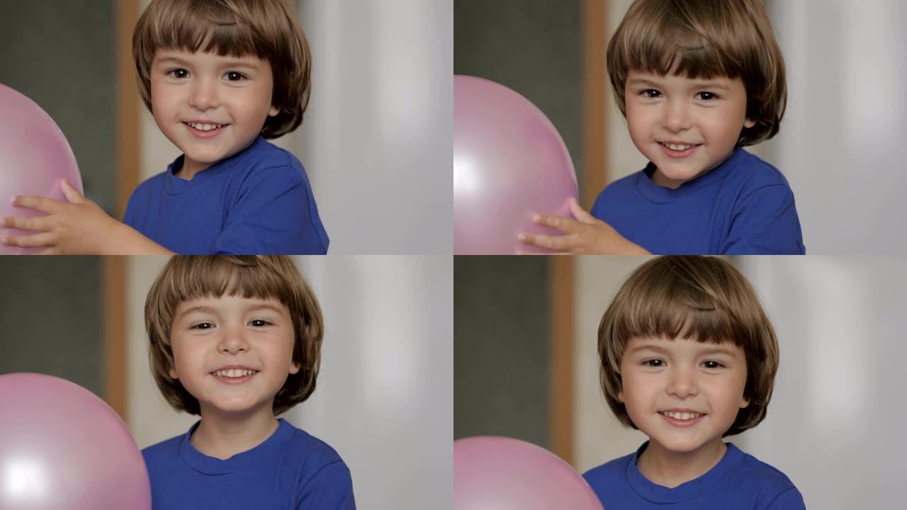 小男孩从气球后面望出去，开心地笑了。一个快乐的小孩大笑起来的特写肖像。金发碧眼的童子男孩，在室内大笑