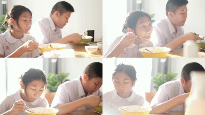 亚洲学童上学前在家一起吃早餐。