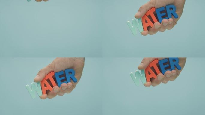 手将彩色字母 “水” 的铭文放入水中。
