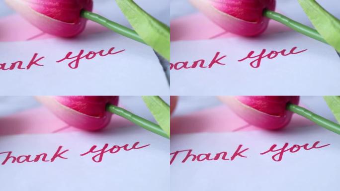 谢谢您在粉红色背景上带有郁金香花的便签上的留言