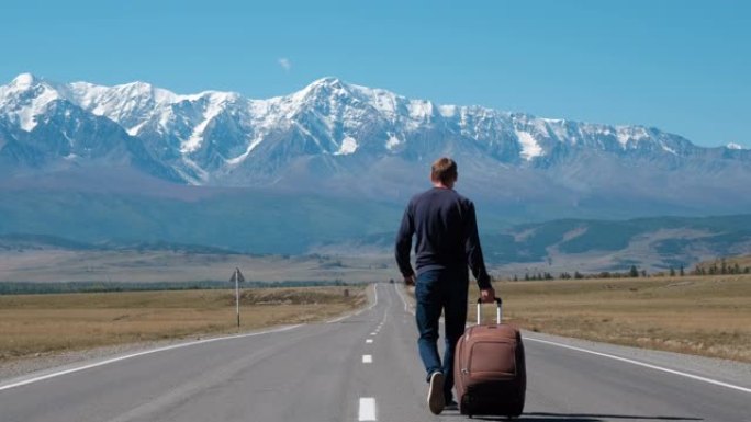 男子在山路上带着手提箱旅行