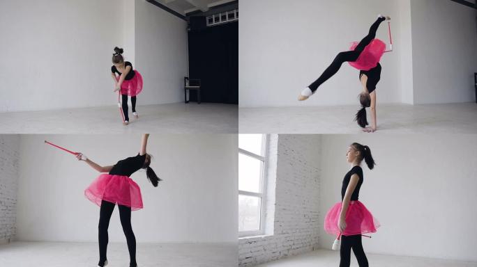 可爱的体操运动员在白色背景的工作室里用狼牙棒在腿上打圈。体操女孩穿着黑色紧身衣和粉色裙子。体操馆