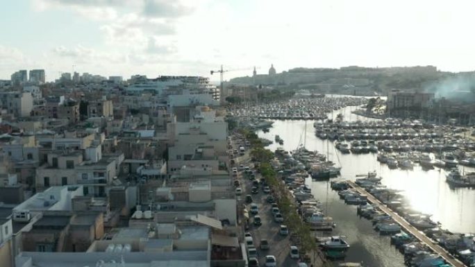 马耳他的小村庄在阳光明媚的日子里在港口的两个教堂钟楼后面露出船，鸟瞰图