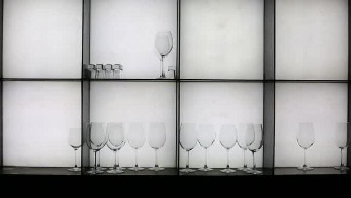 酒吧里各种酒精的透明玻璃杯架子。在白色背景上。