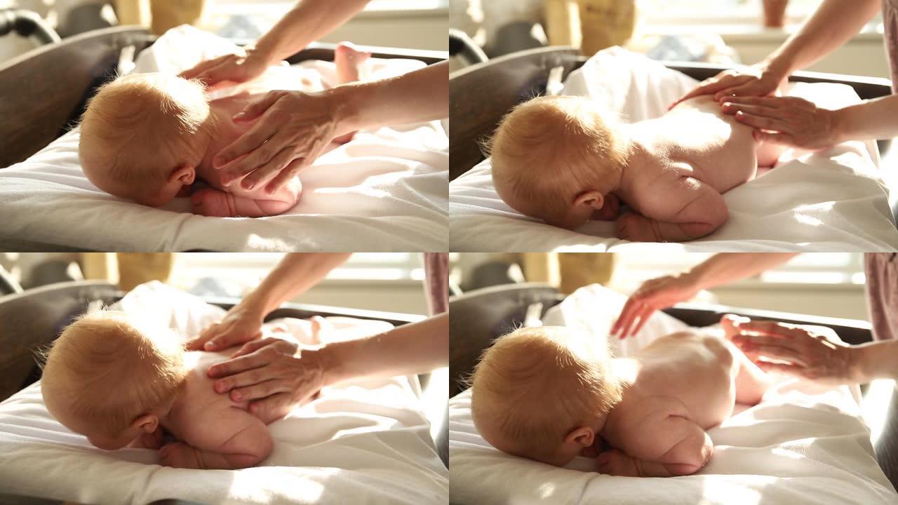 新生婴儿趴在床上，母亲拍着他