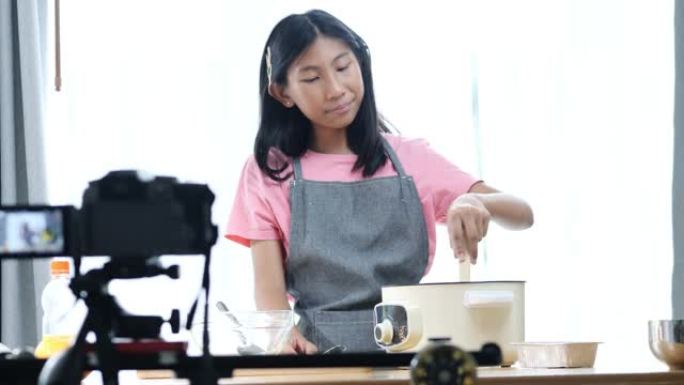 快乐的亚洲女孩视频记录器和有影响力的人在家用相机录制烹饪视频。