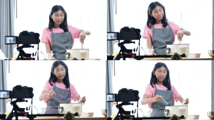 快乐的亚洲女孩视频记录器和有影响力的人在家用相机录制烹饪视频。