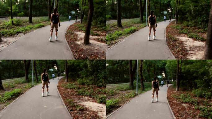 年轻迷人的女性正在公园里溜旱冰。年轻快乐的女性在夏季公园享受轮滑。