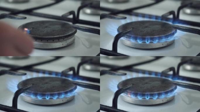 用木制火柴点燃燃气燃烧器。燃气燃烧器在厨房炉灶上用蓝色火焰燃烧。天然气在日常家庭生活中的使用。
