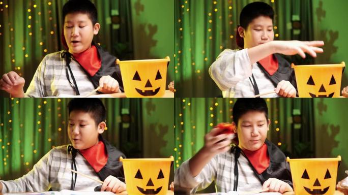 亚洲男孩用魔杖在晚上在家玩万圣节概念。