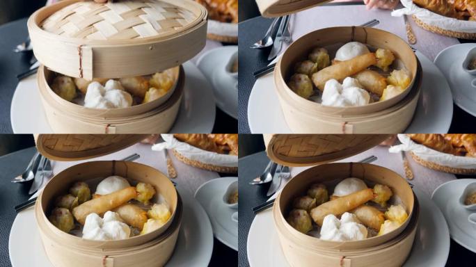 年轻女子在餐桌上打开饺子篮子，传统木篮中的传统中国饺子