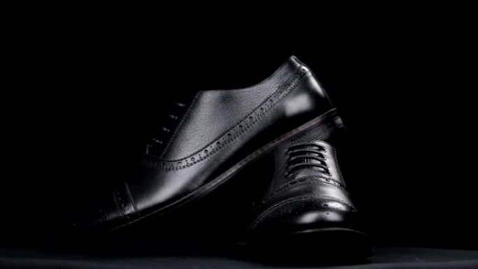黑色背景上的一双经典鞋子的旋转。
