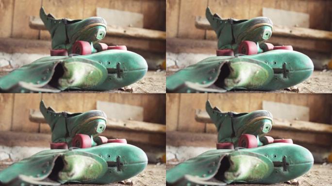 旧绿色旱冰鞋，红色轮子在棚子里/专注于顶级溜冰鞋