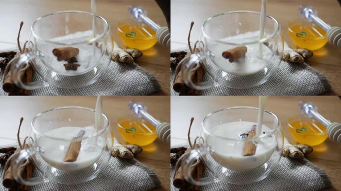 将温热的牛奶倒入传统印度马萨拉柴茶的玻璃杯中。印度马萨拉柴茶香料茶与牛奶在质朴的木制背景，选择性聚焦