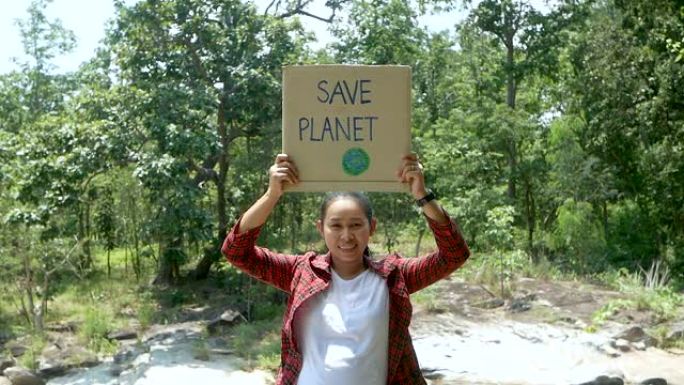 志愿者在森林中举着保护自然的旗帜。世界环境日的概念。“零浪费”。