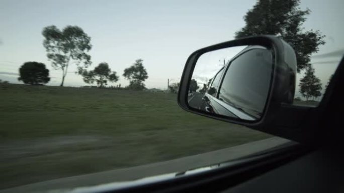 白天驾驶后视镜的乡村道路视图。通过侧镜观察驾驶员的视点。澳大利亚墨尔本。