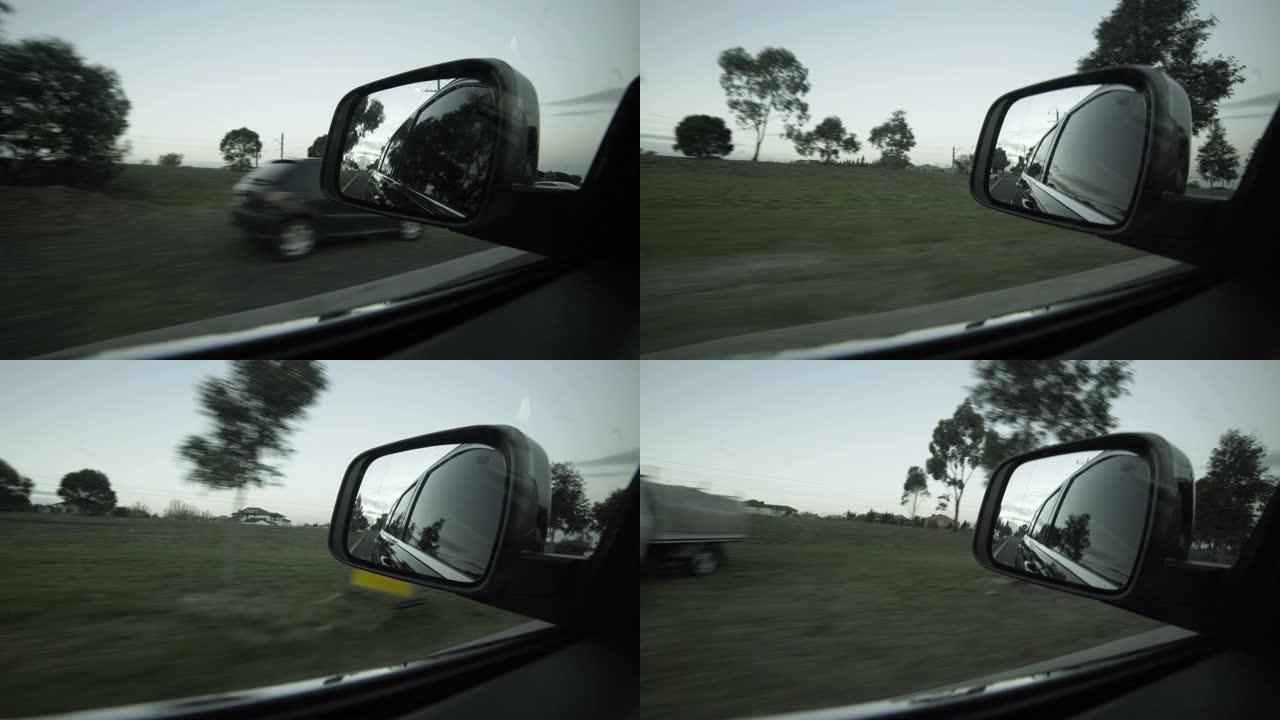 白天驾驶后视镜的乡村道路视图。通过侧镜观察驾驶员的视点。澳大利亚墨尔本。