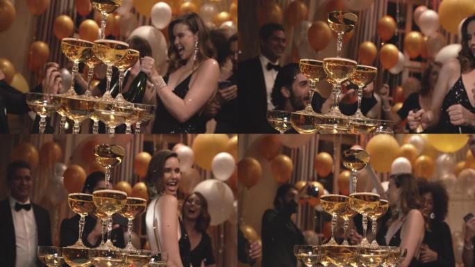 女人在聚会上与朋友在香槟杯金字塔周围跳舞