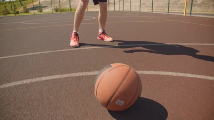 年轻活跃的高加索男子篮球运动员在球场上扔球的特写肖像，背景是建筑物