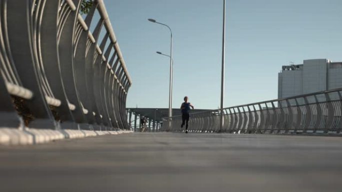 日落时，有动力的年轻女孩沿着海滩长廊快速奔跑。高加索黑发女运动员正在桥上慢跑。跑步和运动概念