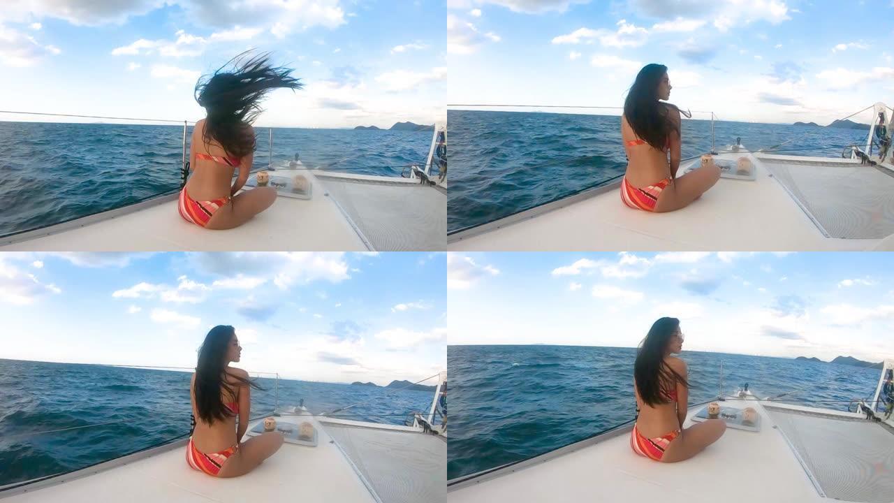 宽镜头美女亚洲女人穿着比基尼幸福在豪华yacth船甲板上，蓝天和泰国海湾芭堤雅