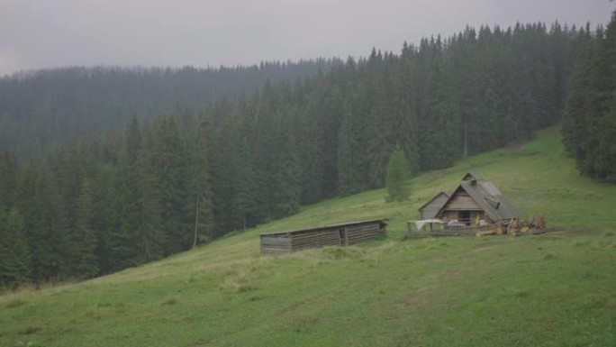 风景秀丽的山村景观。草地中央阴天的老山木屋。