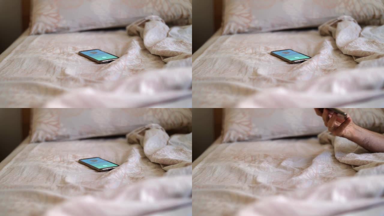 智能手机开始在未整理的床上响起，一只手抓住它