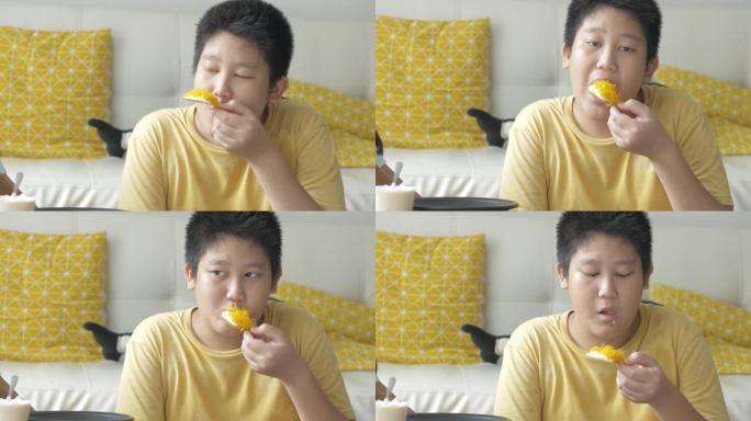 快乐的亚洲男孩在家吃黄油奶油零食，生活方式理念。