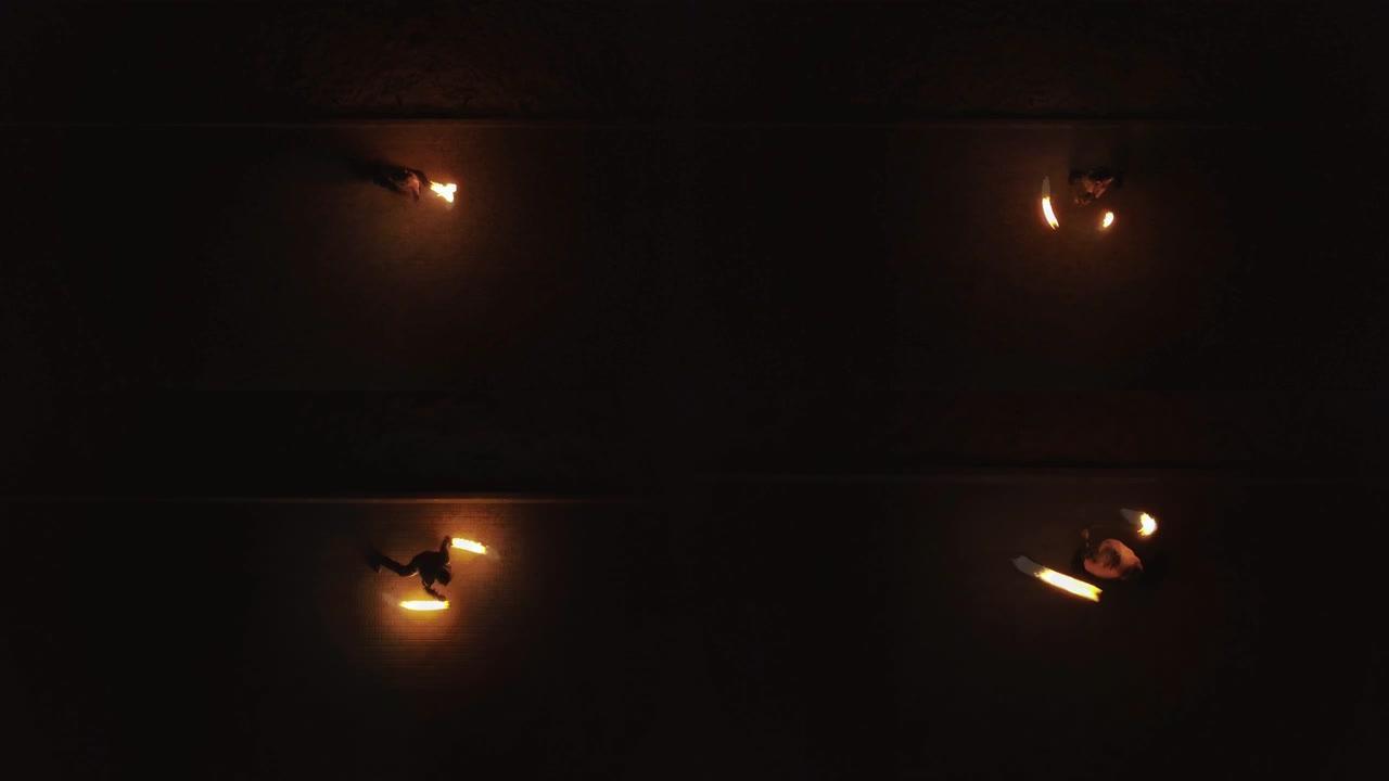 空中: 年轻男性用火捣鬼，旋转两个燃烧的火炬