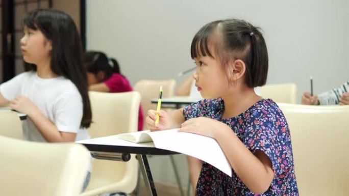 亚洲儿童在学校一起学习和写作教室。教育概念。