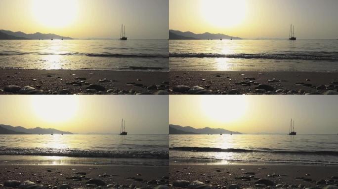 在金色的早晨阳光下，海浪在沙滩上起锚的游艇，放松和豪华的概念。