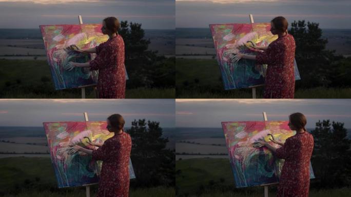 女孩艺术家用手蘸颜料画画。