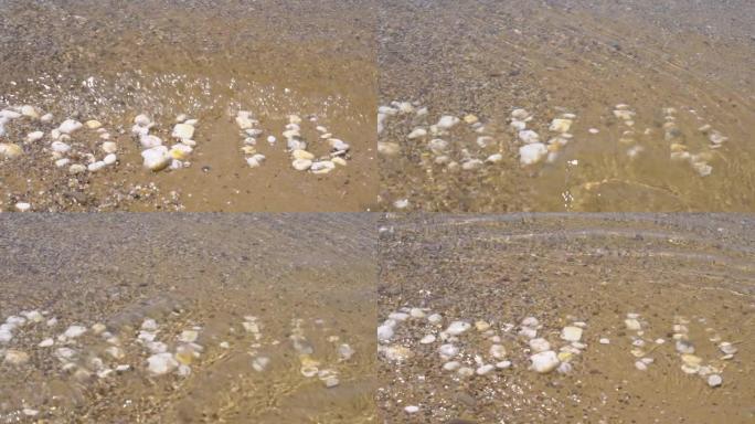 Covid19铭文被水冲走了，湖上的波浪，铭文是由罗克石制成的，海水从海滩上冲走了铭文