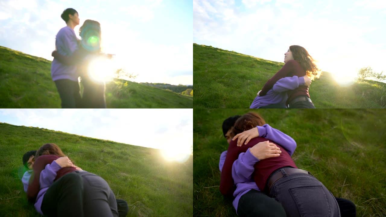女友笨拙地落入男友的怀抱在大自然的户外一起摔倒在草地上