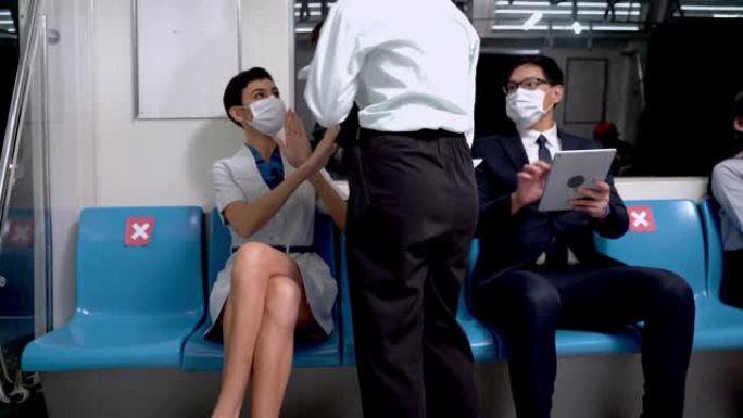 戴口罩的人使用智能手机，坐地铁地铁。女人禁止商业女孩为了社会距离而靠近预防大流行疾病，以防止大流行c