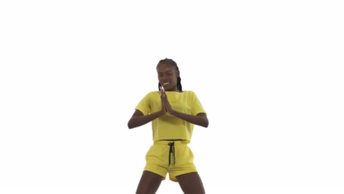 年轻的非洲女子跳舞，展示不同的动作用手，移动臀部。街舞。孤立在白色背景上。