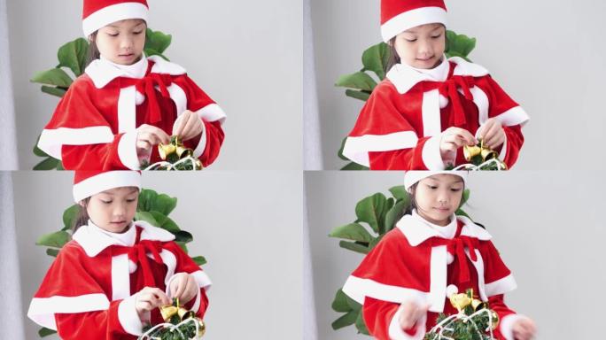 亚洲女孩穿着圣诞老人的服装，在家装饰圣诞树，生活方式概念。