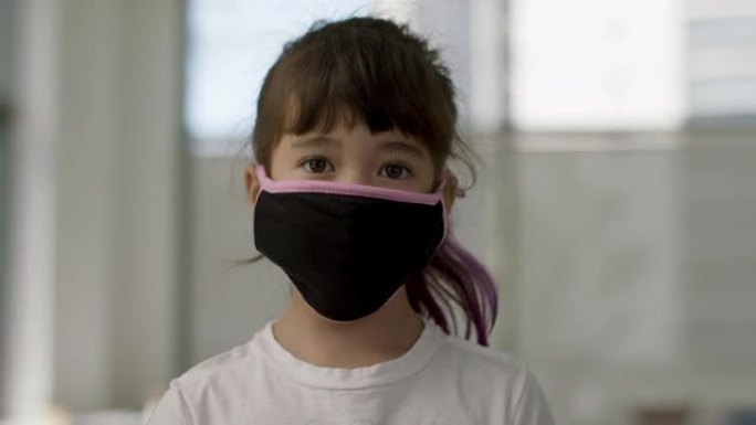 回到学校，采取安全措施。一个戴着面具的小女孩站在肖像台上。