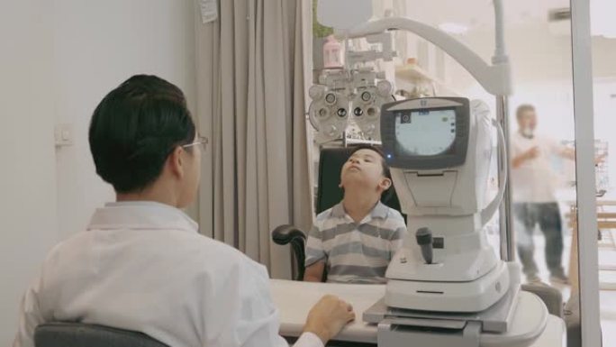 验光师用光学测光仪测量男孩的视力-股票视频