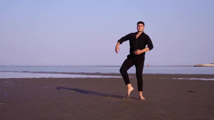 黑衣人在空旷的海滩上表演经典的芭蕾舞